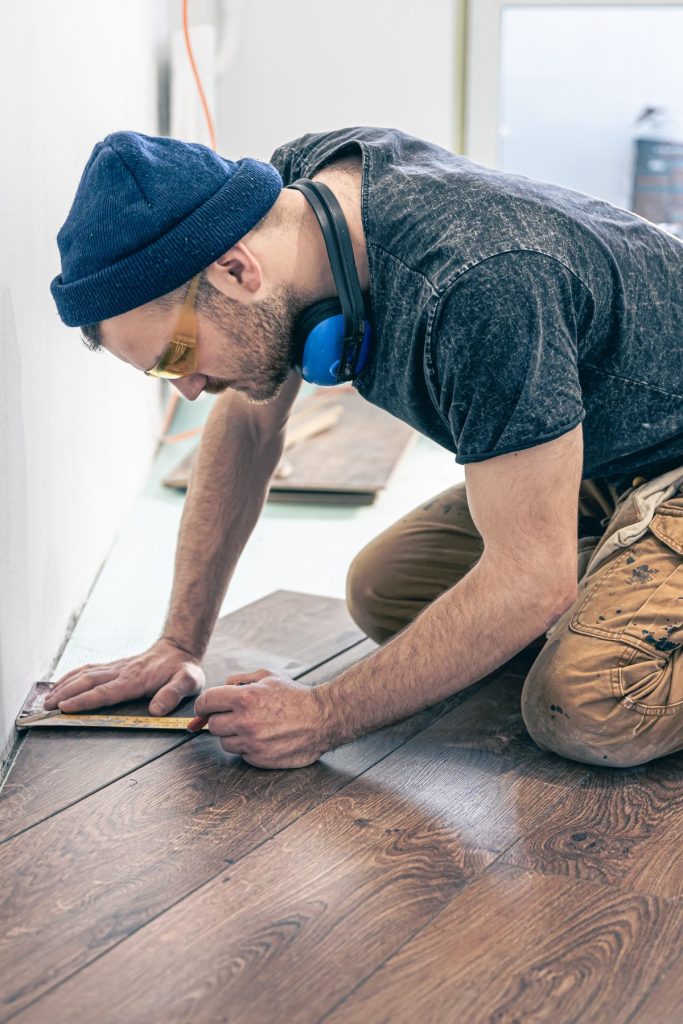Poseur de parquet qui trace une découpe sur une lame