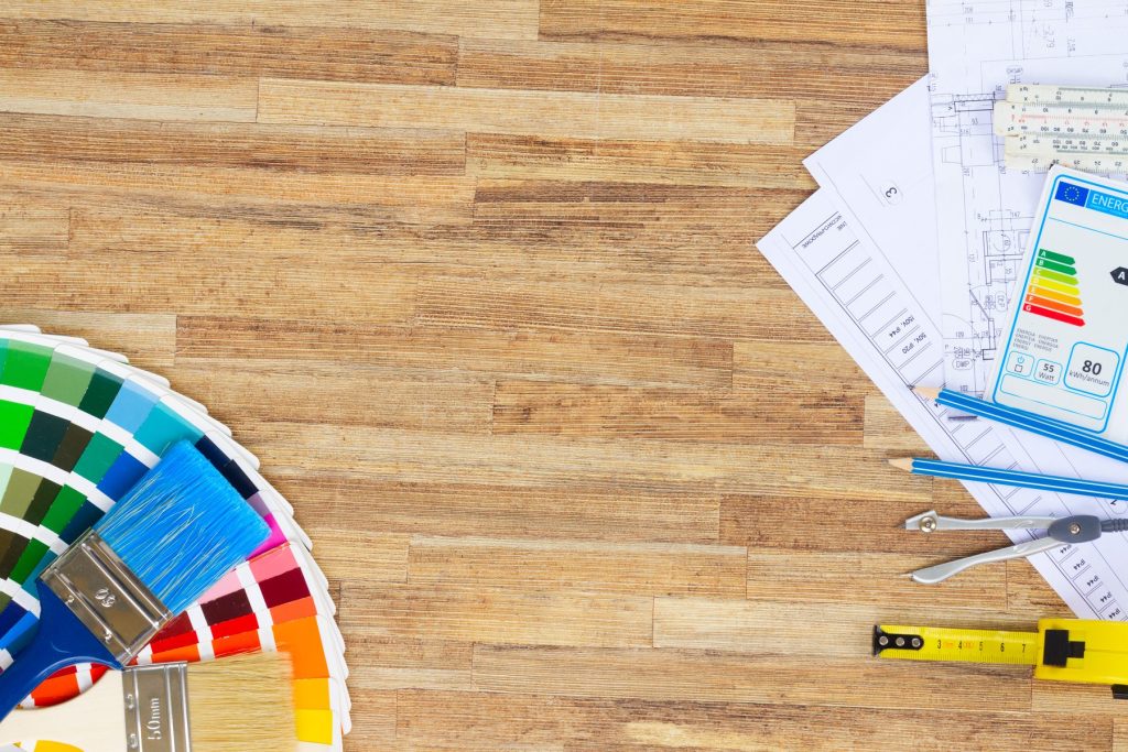 Plans, nuancier et mètre posés sur un parquet