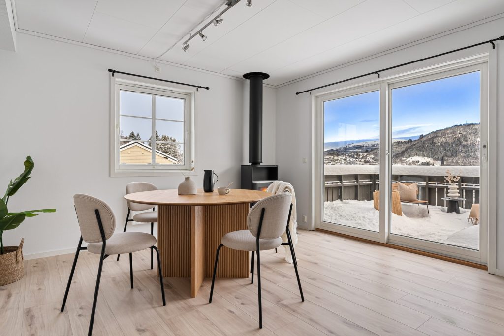 Coin repas sur parquet devant une baie ouverte sur la terrasse